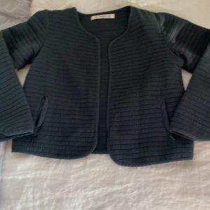  Trekvart kofta  - Jag har storlek 164 och den är i storlek 140 men passar om man vill ha den trekvart den är ungefär marinblå/grön och den är använd cirka 5 gånger 