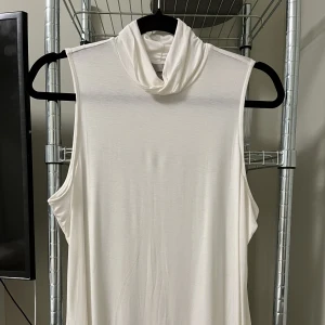 Ärmlös turtleneck topp - Ärmlös turtleneck topp i luftigt tyg, liiite varmvit. Köpt på H&M. Storlek L men sitter som en M tkr jag. Aldrig använd! 🦢