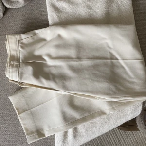 Kostymbyxor  - Vita lyxiga kostymbyxor i strl S, raka som smalnar av något nedtill! En fåll på ena byxbenet har släppt lite men kan enkelt fixas! Betalning sker via swish så hör av dig om du är intresserad🥰