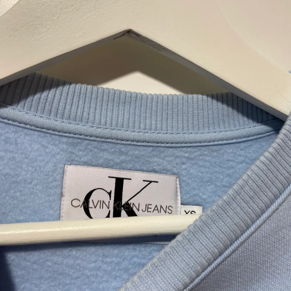 Säljer denna jättefina härliga ljusblå Calvin Klein collegetröjan som även är lätt croppad💙 Köpt i Köpenhamn och är äkta. Säljer då jag knappt använder den längre, är i mycket fint skick! Det står strl XS men skulle även passa en M då den är oversized.. Tröjor & Koftor.