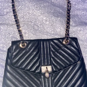 Väska med guld detaljer  - En superfin väska med perfekt storlek och rymligt fack inuti. Den har en trendig guldkedja. 