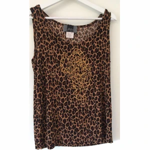 Leopard-linne - Fint leopardmönstrat linne med guldiga diamanter på som ska föreställa ett lejon. Linnet är i fint skick och säljs pga det inte är min stil! Storlek S