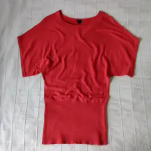 Röd bekväm klänning i ullblandning. Snygg modell som är tight nertill och lös upptill. Man kan justera längden. Storlek S. 85% bomull och 15% ull. 