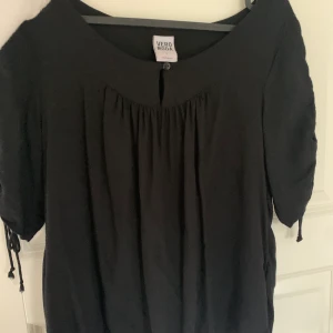 Svart fin blus  - En fin blus, knappt använd. Snörning på sidan.  
