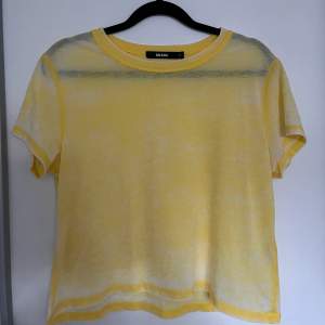 En gul t-shirt i croppad modell från BikBok. Tröjan är i storlek S och i väldigt gott skick!