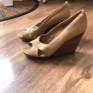 Beiga klackskor pumps från HM  - Höga klackskor med öppen tå från HM. Begagnade men i bra skick. Beiga. Mocka. Strl 39