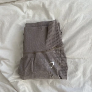 Gymshark träningstights  - Jag säljer dessa nästan oanvända beiga träningstightsen från Gymshark i storlek M. Jag är 165cm och bär S-M för referens. Använda & tvättade endast 1 gång. Om du har övriga frågor eller vill ha fler bilder hmu! Köpare står för frakt & betalning med swish.