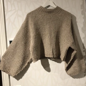 GinaTricot Stickad tröja - Croppad modell med ballongarm. Stl xxs. Färgen är grå-brun