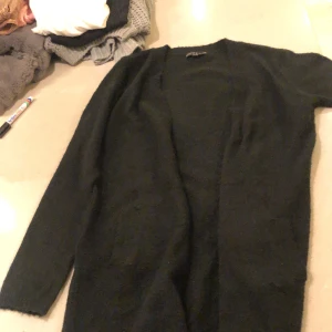 Kofta 146/152 - Svart stickad lång kofta. I storlek 146/152.