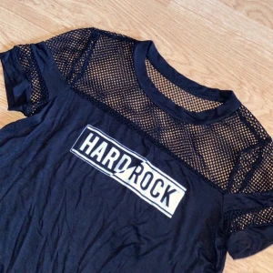 Hard rock café t-shirt - Hard rock café t-shirt/magtröja med ”fishnet” detalj, strl S, aldrig använd.  Kom med bud om ni vill Kan mötas upp mellan Uppsala-Gävle  Postar om du betalar frakt💕   TRYCK INTE PÅ KÖP NU 