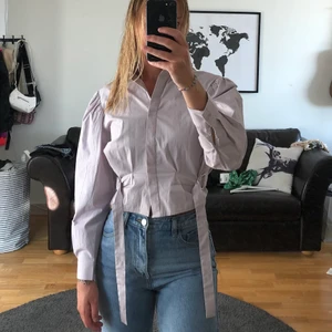 Lila skjortblus NA-KD - Lila skjortblus med snygg snörning i midjan, oanvänd från NA-KD x Emma Ellingsen, stl 34. Köparen står för frakten, kan också mötas i Kalmar! 