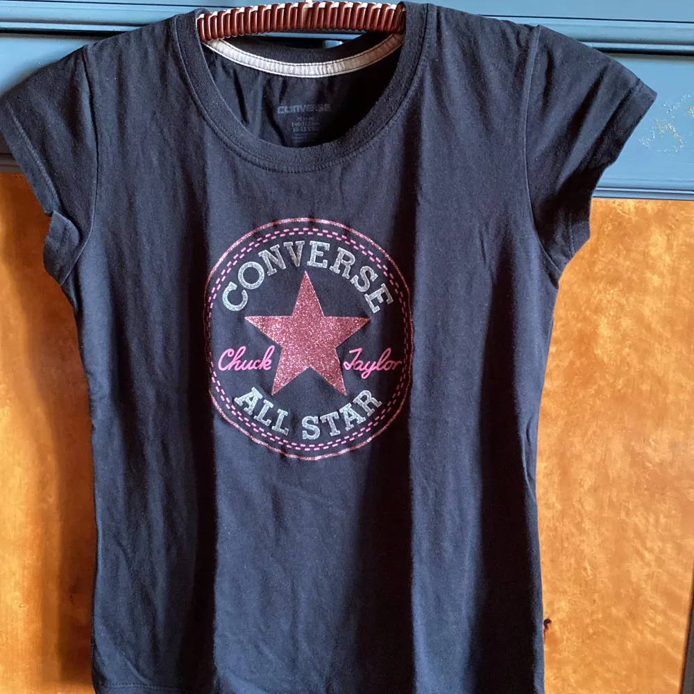 Välvårdad T-shirt. Den är barnstorlek men passar xs/s lika bra.  Stjärnan och ringen i emblemet är i glitter . T-shirts.