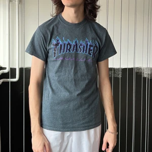 Thrasher Tee Grå - En Grå Thrasher T-Shirt med i min åsikt den snyggaste eldlogotypen 😍 Säljes pga växt ur den. Storlek S. Bra skick🖤