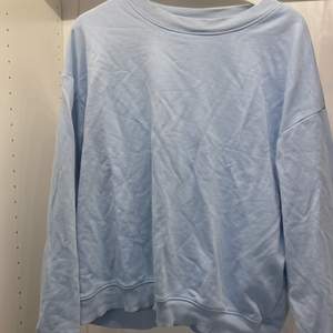 En babyblå sweatshirt från monki. Skrynklig men väldigt bra skick. Inte så varm så bra till sommar/vår. Köpt för ca 200kr  