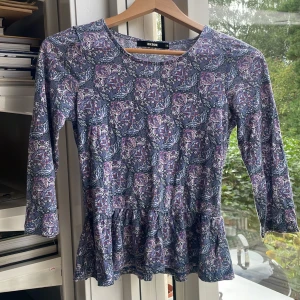 Lila blommig tröja från Bikbok - Stl xs. Tröjan är lite utsvängd längst ner. Ger en fin touch. Lite urtvättade men forfarande fin i färgen, annars inget fel på den.