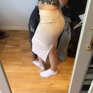 Beige ribbad kjol med slits - Säljer en superfin beige kjol i ribbat material. Den har en snygg slits på sidan!! Jätte bra passform💘