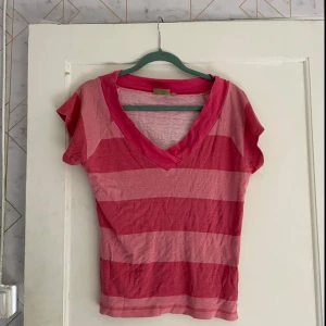 Rosa randig topp från My Wear - Säljer en rosa randig topp från My Wear i storlek 44/46. Den har en v-ringad hals och korta ärmar, perfekt för sommardagar. Materialet känns mjukt och bekvämt.