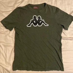 Olivgrön t-shirt från Kappa - Olivgrön T-shirt från kappa i fint skick. Tveka inte att höra av dig om du har frågor eller vill ha fler bilder!