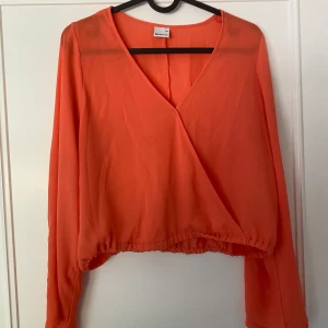 Blus - En jättefin långärmad blus i korallorange. Storlek M men passar även som S
