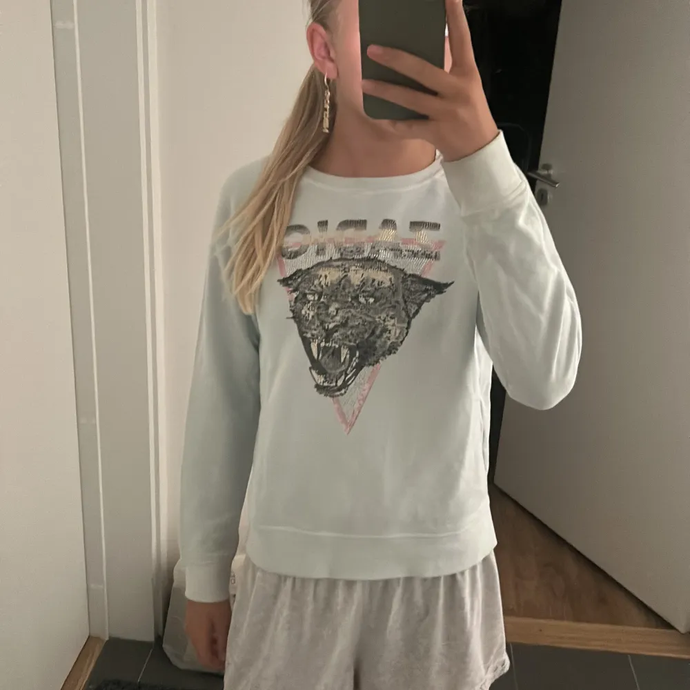 Säljer en supercool baby blå tröja från Zadig & Voltaire. Den har ett stort tryck av en panter på framsidan med texten 'ZADIG' ovanför. Tröjan är långärmad och gjord av bomull, vilket gör den både bekväm och stilren. Perfekt för höst och vår! 🐾. Neuletakit & Villapaidat.