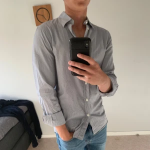 Randig skjorta från Filippa K - Säljer denna vit och blå randiga skjortan från Filippa K. Storleken är XS men passar även S. Hör av dig vid frågor och funderingar!