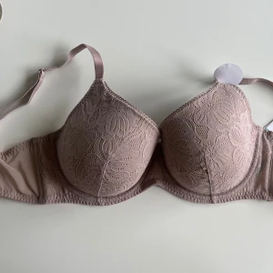 Beige spets-bh - Säljer en superfin beige bh med spetsdetaljer och justerbara axelband. Den är helt oanvänd med prislapp kvar. säljer för att den var för liten💕💕