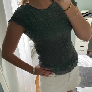 Mörkgrön topp med struktur - Säljer en snygg mörkgrön topp med korta ärmar i strukturerat material från Only. Toppen har en tight passform och är perfekt för både vardag och fest. Använd fåtal gånger🥰