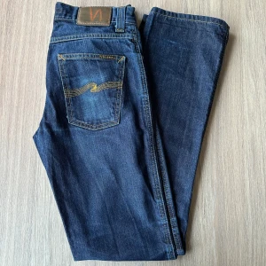 Nudie Jeans Slim Jim, storlek W30 L34 - Nudie Jeans av modell Slim Jim. Trots sitt namn skulle jag säga att det är en rak passform som inte alls är slim fit på samma sätt som Grim Tim exempelvis, dessa är nog mer lika nya passformen Rad Rufus men lite mindre i midjan än motsvarande storlek för rad rufus. Bra skick, lite slitmärken på benen. Tvätt: Dry broken twill  ﻿Hör av dig om du har några funderingar.