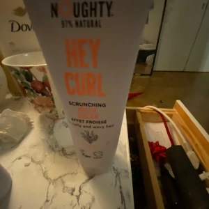 Hårvårdsprodukter från Noughty - Säljer ett set med hårvårdsprodukter från Noughty, inklusive 'Hey Curl' scrunching gel och 'Wave Hello' curl defining cream. Produkterna är 97% naturliga och veganska, perfekta för lockigt och vågigt hår.