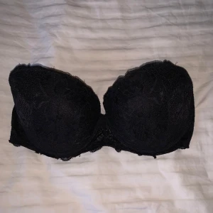 Svart spets-BH från Victoria secret- Pink - Snygg svart BH med spetsdetaljer från Pink. Insidan är fodrad i en härlig rosa färg. Perfekt för att känna sig både bekväm och stilren.