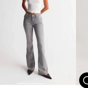 Grå bootcut jeans- gina - Snygga grå bootcut jeans med klassisk femficksdesign. Perfekta för en avslappnad stil med en touch av retro. Passar bra till både sneakers och klackar. Endast använd 1 gång. Vid fler bilder eller andra frågor, tvecka inte att höra av.