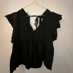 Svart topp med knytband - Snygg svart topp från 157 med knytband i ryggen och v-ringad design. Kommer inte till användning❣️❣️