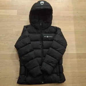 Svart dunjacka från Sail Racing - Säljer en svart dunjacka från Sail Racing med huva och dragkedja. Den är i mycket bra skick och passar storlek XS. Om du har andra frågor eller funderingar är det bara att skicka ett meddelande ✅️