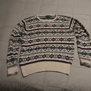  Polo Ralph Lauren fair isle tröja ”Vintage ” - Säljer en snygg mönstrad tröja från Polo Ralph Lauren i storlek M. Tröjan har ett färgglatt mönster i grönt, blått och vinrött på en krämfärgad bas. Den är tillverkad i en blandning av silke och andra material, vilket ger en lyxig känsla. Perfekt för kyliga dagar!