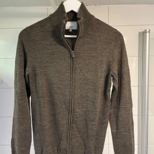 Brun hel zip från Bläck - Snygg brun kofta från Bläck med dragkedja och hög krage. Perfekt att ha skjorta eller t-shirt under. Säljer pga för liten. Storlek M. Nypris tror jag runt 800 kr, mitt pris 199 kr. Mycket gott skick då den är sparsamt använd. Hör av er vid frågor.
