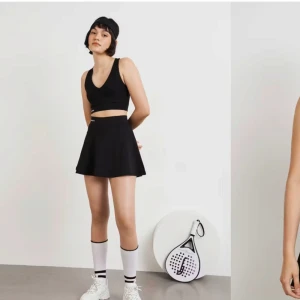 Svart padelkjol från Gina Tricot - Snygg svart padelkjol från Gina Tricot med korta cykelbyxor under. Perfekt för en sportig look eller en avslappnad dag. Ny med tags.