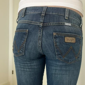Lågmidjade bootcut jeans - Jätte snygga lågmidjade bootcut jeans från Wrangler som aldrig är använda. Midjemått 37 och innerbenslängd 80 cm