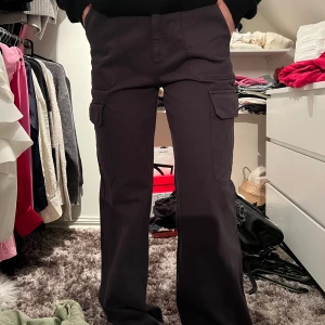 Svarta cargobyxor - Snygga svarta cargobyxor med praktiska fickor på sidorna. Byxorna har en bootcut-stil och är perfekta för en avslappnad look. De har en normal passform och är tillverkade i ett slitstarkt material.