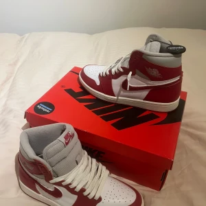 OANVÄNDA Nike Air Jordan 1s - Snygga Nike Air Jordans i en klassisk röd och vit färgkombination. Skorna har hög snörning och en ikonisk design med Nike-loggan på sidan. Perfekta för sneakerheads som vill ha en stilren look. 10/10 skick ALDRIG använda, säljer då de inte alls är min stil längre. Köpa på restocks.se innan de gick i konkurs💰