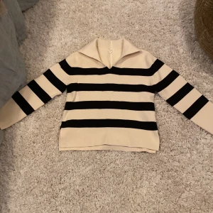Randig tröja i beige och svart - Säljer en snygg randig tröja från arket i beige och svart.Tröjan har långa ärmar och en klassisk krage. Helt ny och har inte kommit till användning.Kom privat för mer bilder , pris kan diskuteras! 