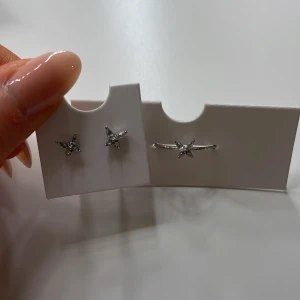 Silverfärgat smyckeset med diamantfjärilar - Snyggt silverset med diamantfjärilar. Ett par örhängen och en ring, de kan köpas seperat. Aldrig använda och är i orginalförpackning 