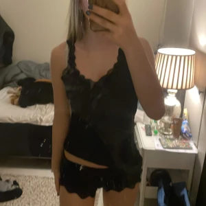 Svart linne med spetsdetaljer - Snyggt pjamaslinne med spetsdetaljer och shorts. 