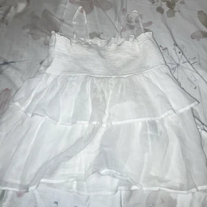 Vit topp  med volanger - Säljer min vita topp från gina då den inte används längre. Toppen har inga defekter och är som helt ny. Storlek 160 / xs  och sitter jättefint