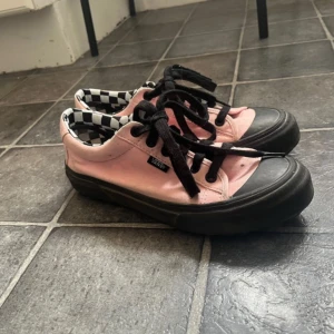LAZY OAF X Vans - Snygga rosa Vans sneakers med svart snörning och svart sula. Skorna har en cool svartvit rutigt mönster på insidan. Perfekta för en avslappnad stil. Dessa är limited edition lazy oaf x vans “Sorry I’m late” och är storlek 38, det var ett tag sedan jag köpte dessa så de ser lite slitna ut men har inte använt dem så mycket! Ställ gärna frågor :)