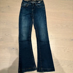 Blå bootcut jeans från LTB - Fallon - Snygga mörkblå bootcut jeans från LTB - modell Fallon. Stl 25 - längd 30. Perfekta för en avslappnad stil med en touch av retro. Passar bra till både sneakers och klackar. Smått fransiga i benslut (se bild). Annars mycket bra skick. 