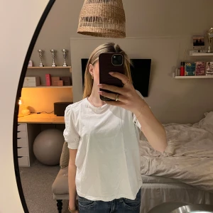 Vit t-shirt från Aware by Vero Moda - Säljer en stilren vit t-shirt från Aware by Vero Moda. T-shirten har korta puffiga ärmar och en klassisk rund halsringning. Perfekt basplagg för alla tillfällen 💕