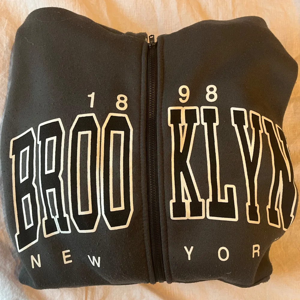 En grå zip hoodie med trycket Brooklyn på framsidan. Använd ett antal gånger så lite smånopprig💕. Hoodies.