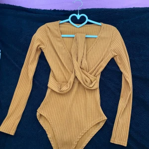 Ginatricot - Body - Mjuk, inte så tunn i material, stretchig, ribbad , sitter perfekt, den har en stängd rygg med en v- ringad framsida med långa ärmar 