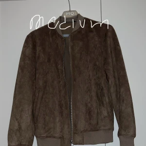 Brun mocka bomberjacka från Zara - Säljer en snygg brun mocka bomberjacka från Zarai storlek medium. Jackan har en dragkedja framtill och ribbade muddar vid ärmslut och nederkant. Perfekt för höst och vår! 🧥🍂
