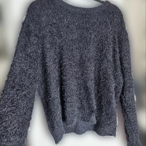 Svart fluffig tröja - Säljer en svart fluffig tröja som är superbra för kalla dagar. Storlek L/XL. Den har en normal passform med långa ärmar. Tröjan är i bra skick och passar perfekt för dig som är frussen. 🩶